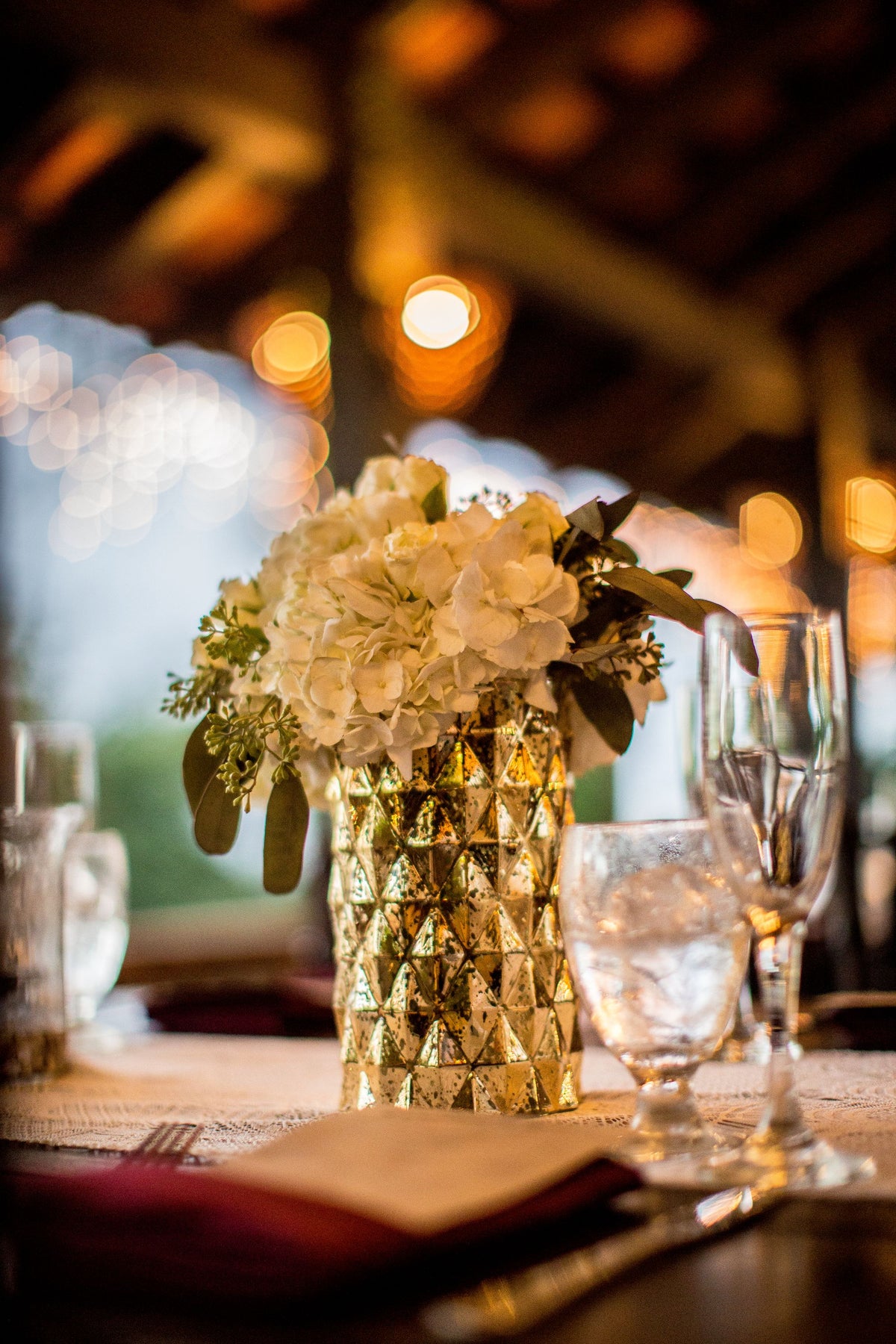 A white hydrangea centerpiece on a set dining table