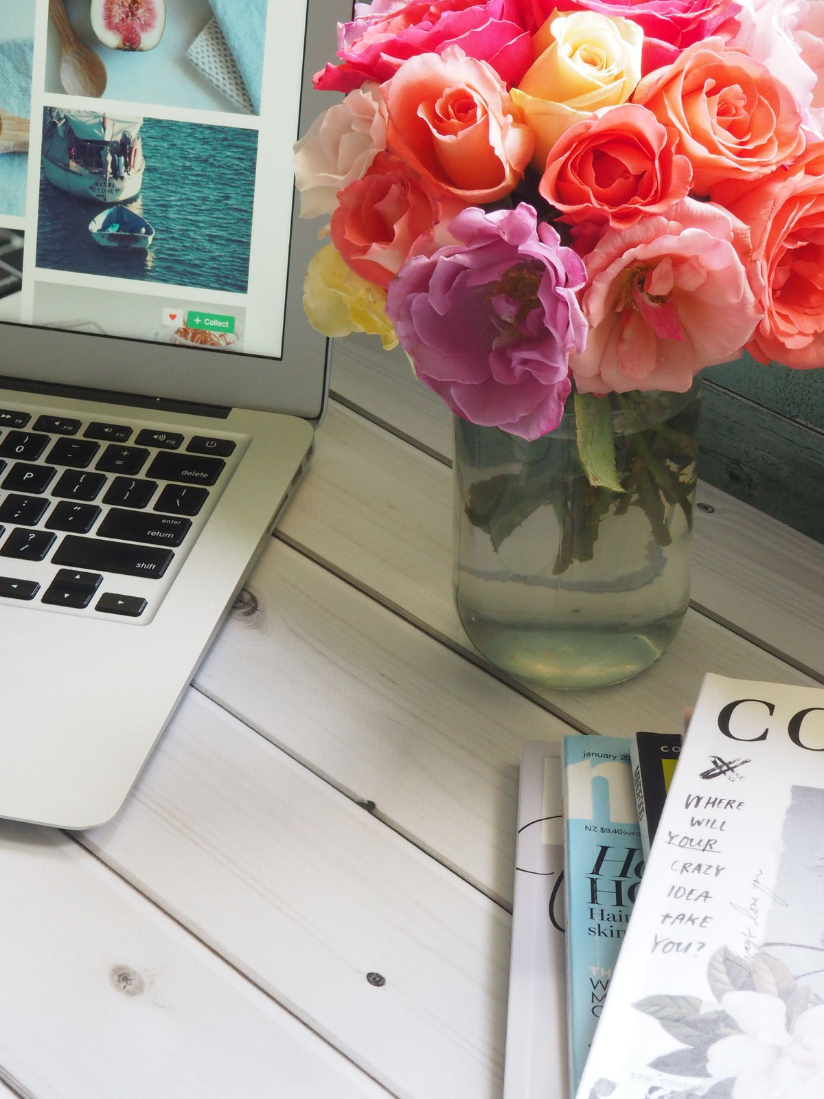 Fresh mixed roses in a glass vase on an office desk
